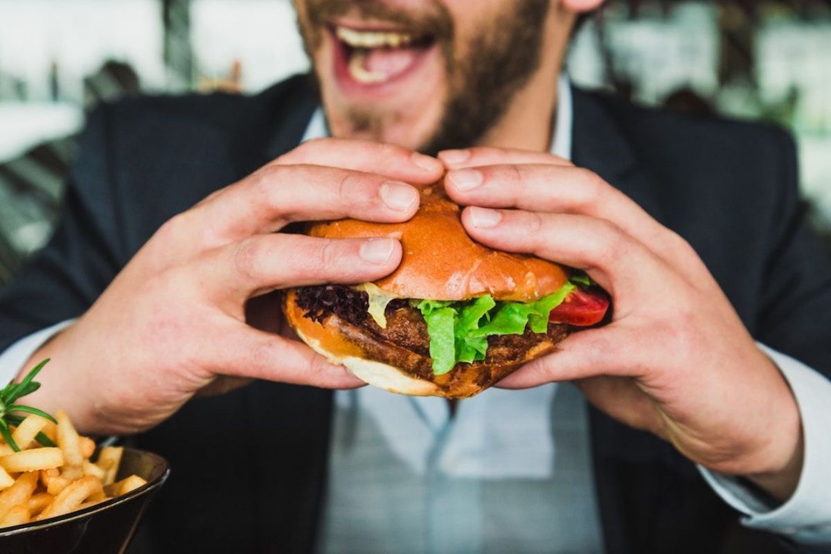 man eating burger with two hands